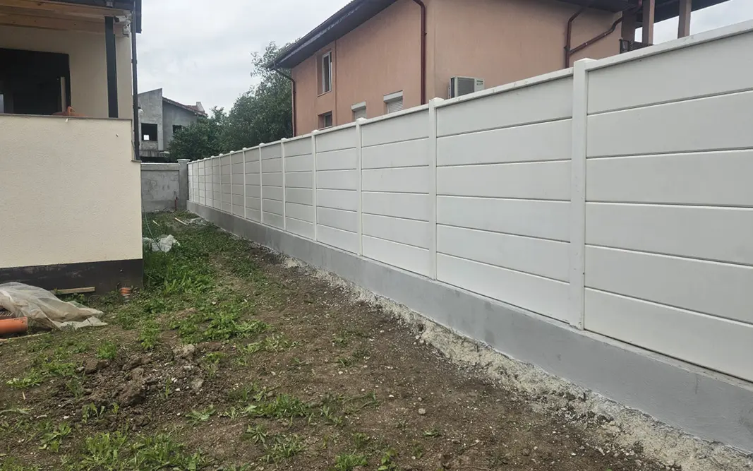 Bela betonska ograda sa glatkim panelima na betonskoj sokli