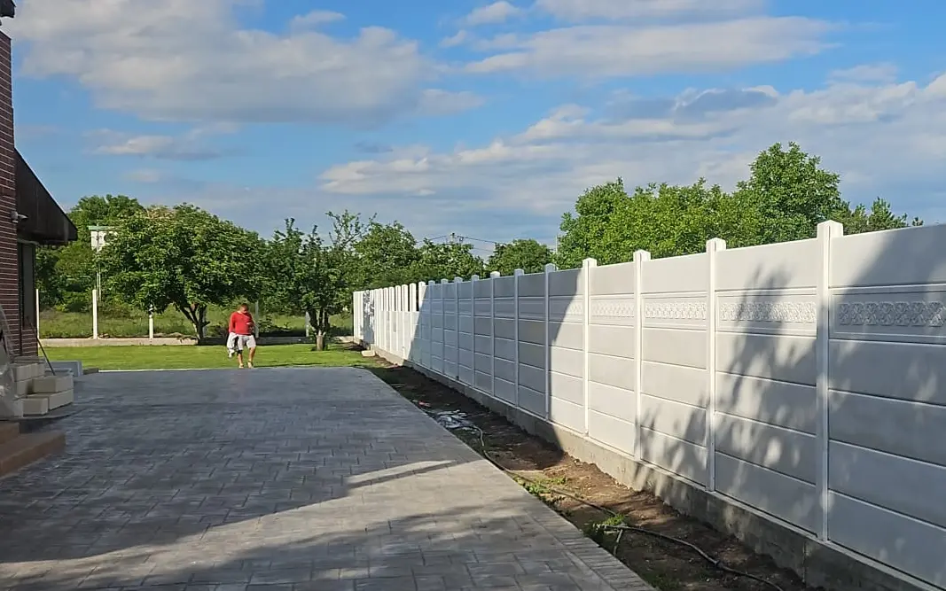 Bela betonska ograda sa dekorativnim frizom u gornjem delu