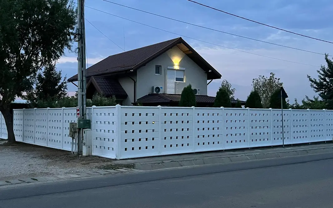 Bela ažurna betonska ograda sa kvadratnim otvorima oko kuće