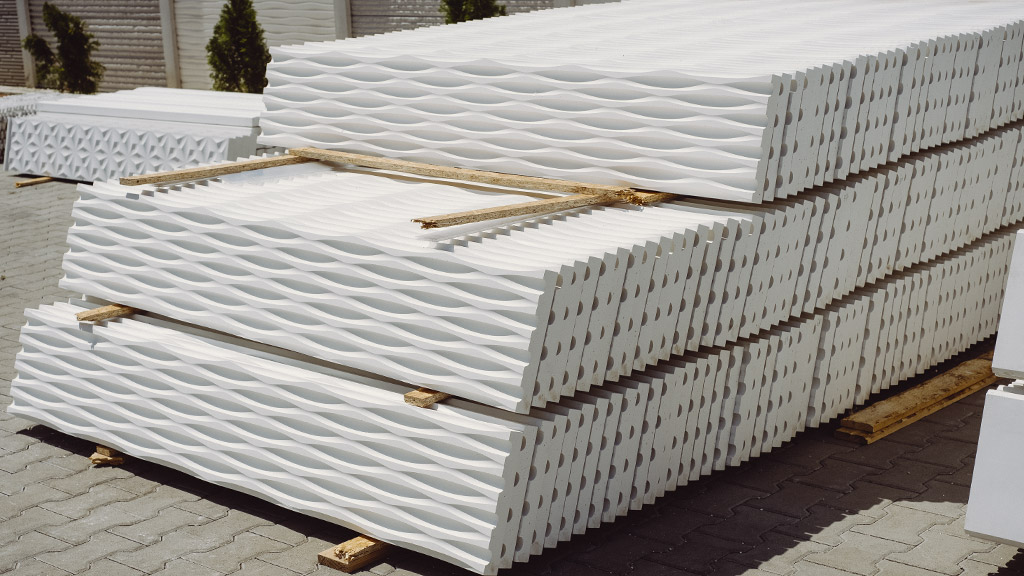 Beli betonski paneli za ogradu, složeni jedan na drugi u dvorištu fabrike